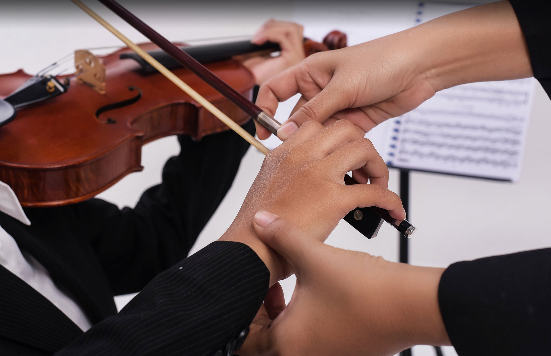 Hands instructing violin player